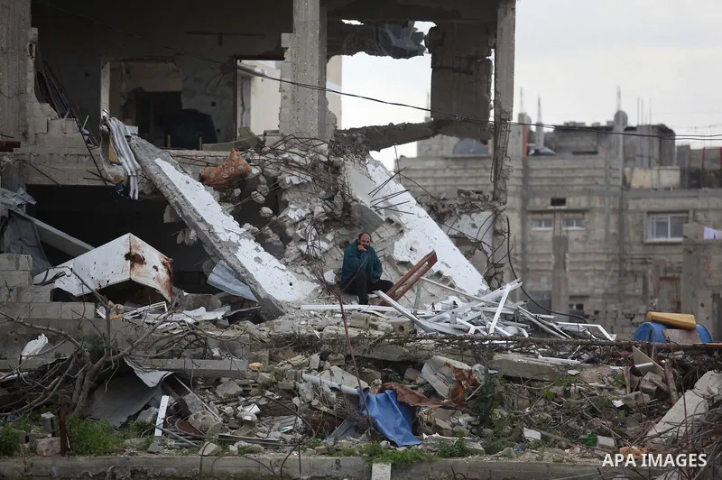 A Palestinian man sits on the rubbles of houses, which were destroyed during the recent Israeli offensive on Gaza Strip, in the last day of 2014, in Shijaiyah neighborhood, east Gaza city on January 27, 2015. The main U....