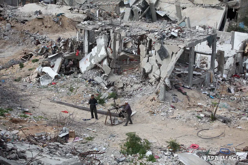 Palestinian workers extract iron from the rubbles of houses that witnesses said was destroyed by Israeli shelling during the most recent conflict between Israel and Hamas, in Shijaiyah neighborhood, east Gaza city on Jan...