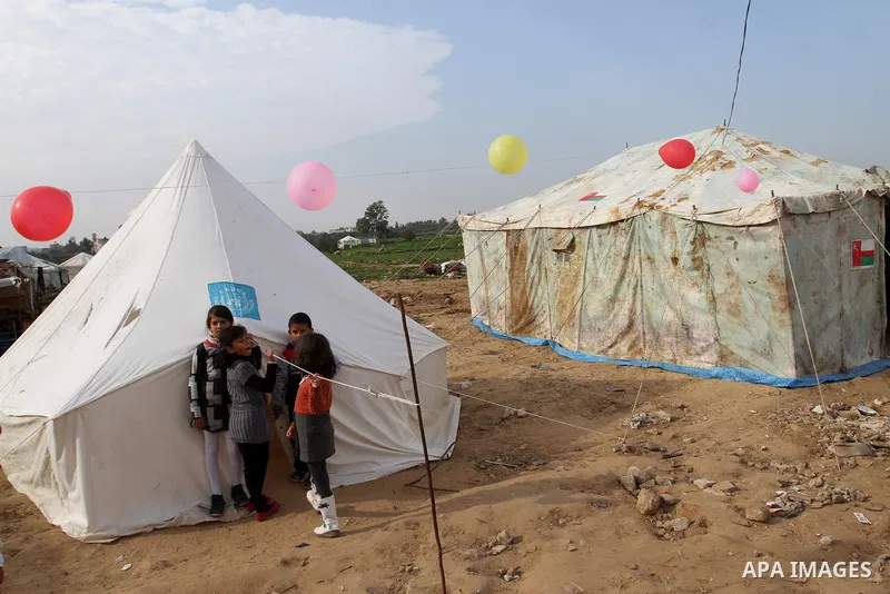 Palestinian children play outside tents near the ruins of their houses which witnesses said were destroyed by Israel shelling during a 50-day conflict last summer, east of Khan Younis in the southern Gaza Strip January 2...