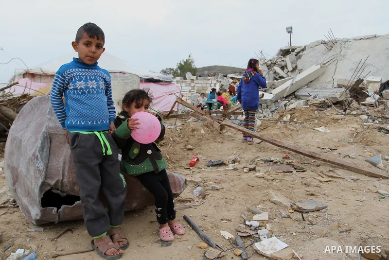 Palestinian children play outside tents near the ruins of their houses which witnesses said were destroyed by Israel shelling during a 50-day conflict last summer, east of Khan Younis in the southern Gaza Strip January 2...