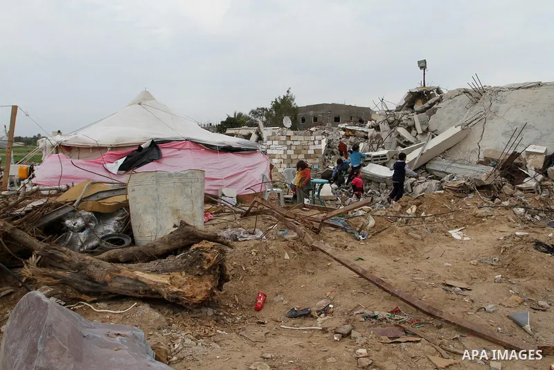 Palestinian children play outside tents near the ruins of their houses which witnesses said were destroyed by Israel shelling during a 50-day conflict last summer, east of Khan Younis in the southern Gaza Strip January 2...