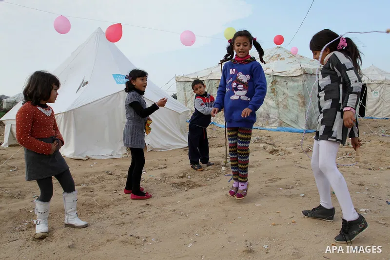 Palestinian children play outside tents near the ruins of their houses which witnesses said were destroyed by Israel shelling during a 50-day conflict last summer, east of Khan Younis in the southern Gaza Strip January 2...
