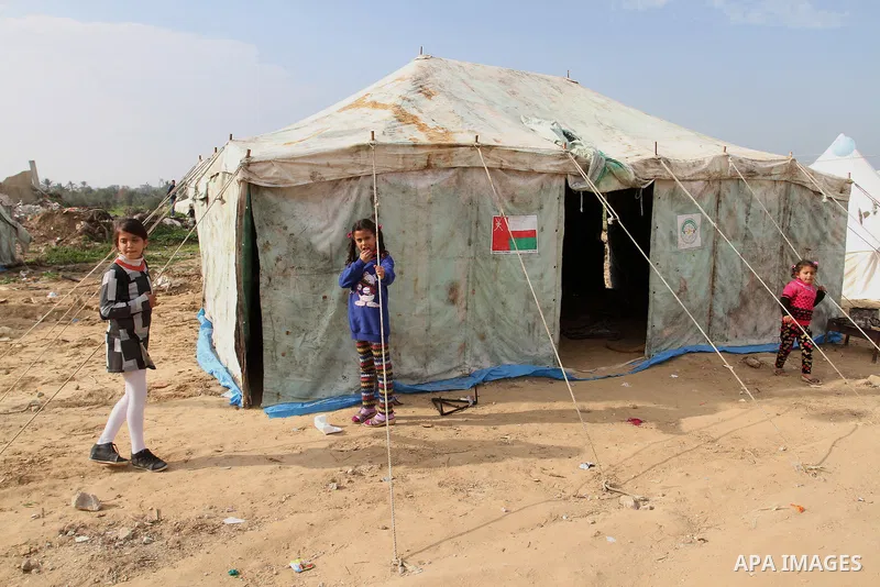 Palestinian children play outside tents near the ruins of their houses which witnesses said were destroyed by Israel shelling during a 50-day conflict last summer, east of Khan Younis in the southern Gaza Strip January 2...