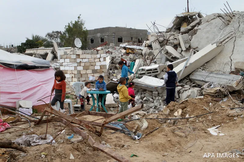 Palestinian children play outside tents near the ruins of their houses which witnesses said were destroyed by Israel shelling during a 50-day conflict last summer, east of Khan Younis in the southern Gaza Strip January 2...