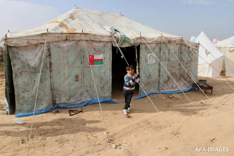 A Palestinian boy stands outside a tent near the ruins of his family's house which witnesses said were destroyed by Israel shelling during a 50-day conflict last summer, east of Khan Younis in the southern Gaza Strip Jan...