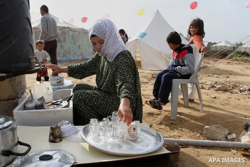 A Palestinian woman, whose house was destroyed by what witnesses said was Israel shelling during a 50-day conflict last summer, works outside her tent east of Khan Younis in the southern Gaza Strip January 27, 2015. The...
