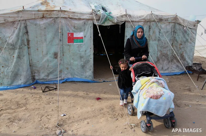 A Palestinian woman, whose house was destroyed by what witnesses said was Israel shelling during a 50-day conflict last summer, walks outside her tent east of Khan Younis in the southern Gaza Strip January 27, 2015. The...