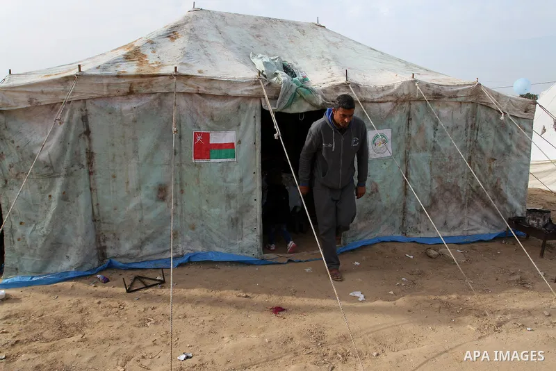A Palestinian man, whose house was destroyed by what witnesses said was Israel shelling during a 50-day conflict last summer, walks outside his tent east of Khan Younis in the southern Gaza Strip January 27, 2015. The ma...