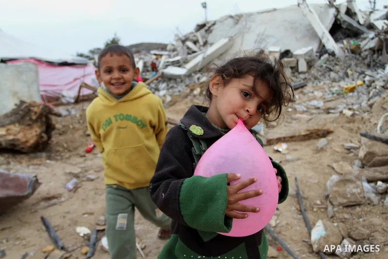 Palestinian children play outside tents near the ruins of their houses which witnesses said were destroyed by Israel shelling during a 50-day conflict last summer, east of Khan Younis in the southern Gaza Strip January 2...