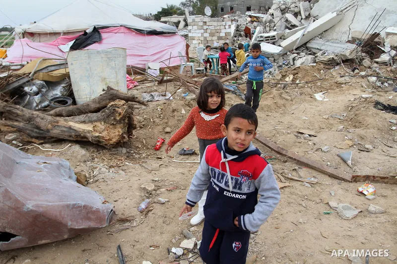 Palestinian children play outside tents near the ruins of their houses which witnesses said were destroyed by Israel shelling during a 50-day conflict last summer, east of Khan Younis in the southern Gaza Strip January 2...