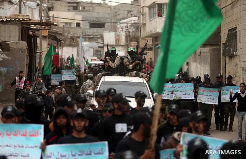 Palestinian members of Ezz Eddin al-Qassam brigades hold weapons as they march during a protest rally in support of the Prophet Mohammed in Gaza City on January 27, 2015. Photo by Ashraf Amra