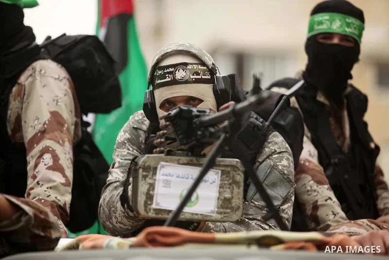 Palestinian members of Ezz Eddin al-Qassam brigades hold weapons as they march during a protest rally in support of the Prophet Mohammed in Gaza City on January 27, 2015. Photo by Ashraf Amra
