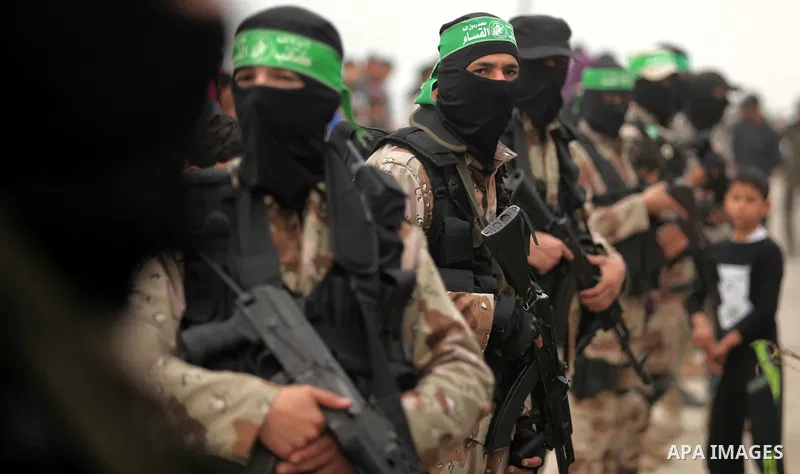 Palestinian members of Ezz Eddin al-Qassam brigades hold weapons as they march during a protest rally in support of the Prophet Mohammed in Gaza City on January 27, 2015. Photo by Ashraf Amra
