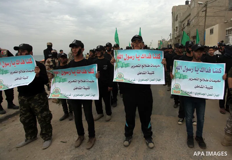 Palestinian youth, who are participating in a Hamas military-style camp, chant slogans as they march during a protest rally in support of the Prophet Mohammed in Gaza City on January 27, 2015. Photo by Ashraf Amra
