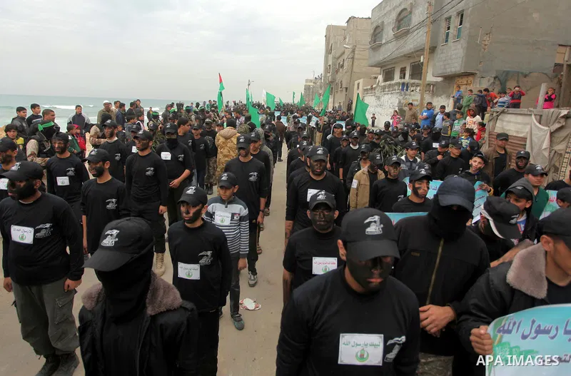 Palestinian youth, who are participating in a Hamas military-style camp, chant slogans as they march during a protest rally in support of the Prophet Mohammed in Gaza City on January 27, 2015. Photo by Ashraf Amra