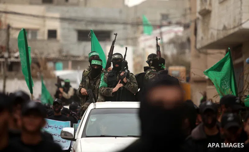 Palestinian members of Ezz Eddin al-Qassam brigades hold weapons as they march during a protest rally in support of the Prophet Mohammed in Gaza City on January 27, 2015. Photo by Ashraf Amra