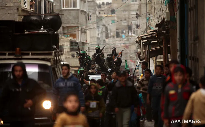 Palestinian members of Ezz Eddin al-Qassam brigades hold weapons as they march during a protest rally in support of the Prophet Mohammed in Gaza City on January 27, 2015. Photo by Ashraf Amra