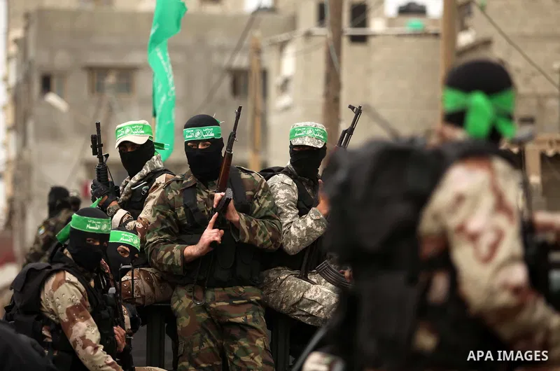Palestinian members of Ezz Eddin al-Qassam brigades hold weapons as they march during a protest rally in support of the Prophet Mohammed in Gaza City on January 27, 2015. Photo by Ashraf Amra