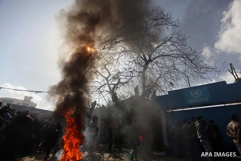 Palestinians burn tires during a protest against the decision by the main U.N. aid agency to suspend payments to tens of thousands of Palestinians for repairs to their homes damaged in last summer's war, outside the head...