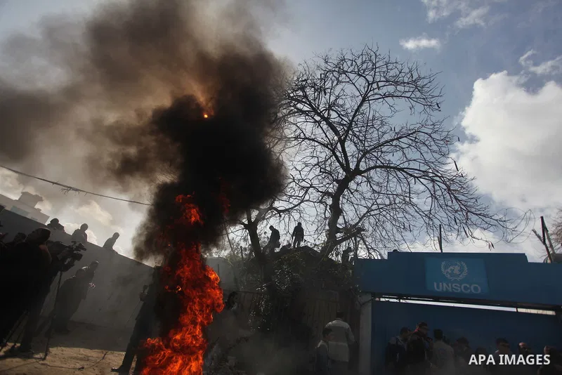 Palestinians burn tires during a protest against the decision by the main U.N. aid agency to suspend payments to tens of thousands of Palestinians for repairs to their homes damaged in last summer's war, outside the head...