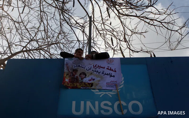 Palestinians burn tires during a protest against the decision by the main U.N. aid agency to suspend payments to tens of thousands of Palestinians for repairs to their homes damaged in last summer's war, outside the head...
