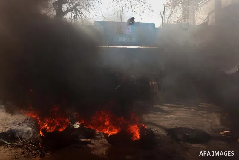 Palestinians burn tires during a protest against the decision by the main U.N. aid agency to suspend payments to tens of thousands of Palestinians for repairs to their homes damaged in last summer's war, outside the head...