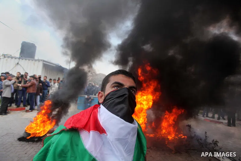 Palestinians burn tires during a protest against the decision by the main U.N. aid agency to suspend payments to tens of thousands of Palestinians for repairs to their homes damaged in last summer's war, outside the head...