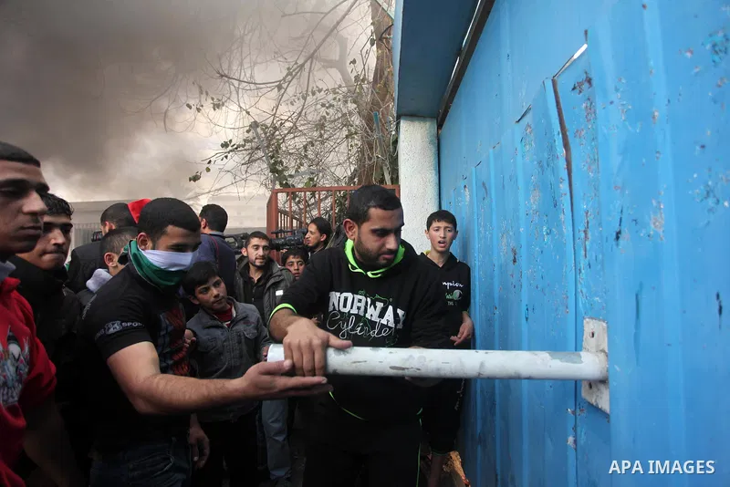 Palestinians take part a protest against the decision by the main U.N. aid agency to suspend payments to tens of thousands of Palestinians for repairs to their homes damaged in last summer's war, outside the headquarters...