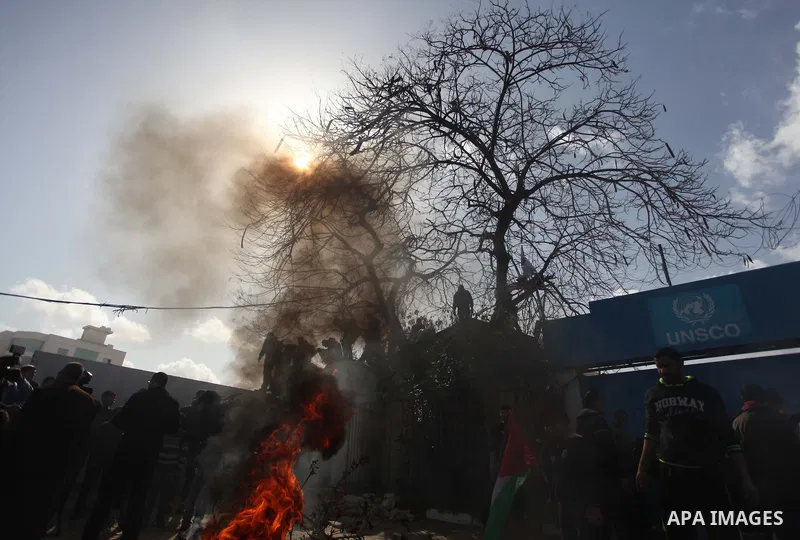 Palestinians burn tires during a protest against the decision by the main U.N. aid agency to suspend payments to tens of thousands of Palestinians for repairs to their homes damaged in last summer's war, outside the head...