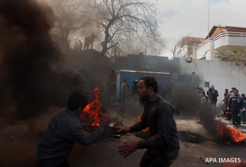 Palestinians burn tires during a protest against the decision by the main U.N. aid agency to suspend payments to tens of thousands of Palestinians for repairs to their homes damaged in last summer's war, outside the head...