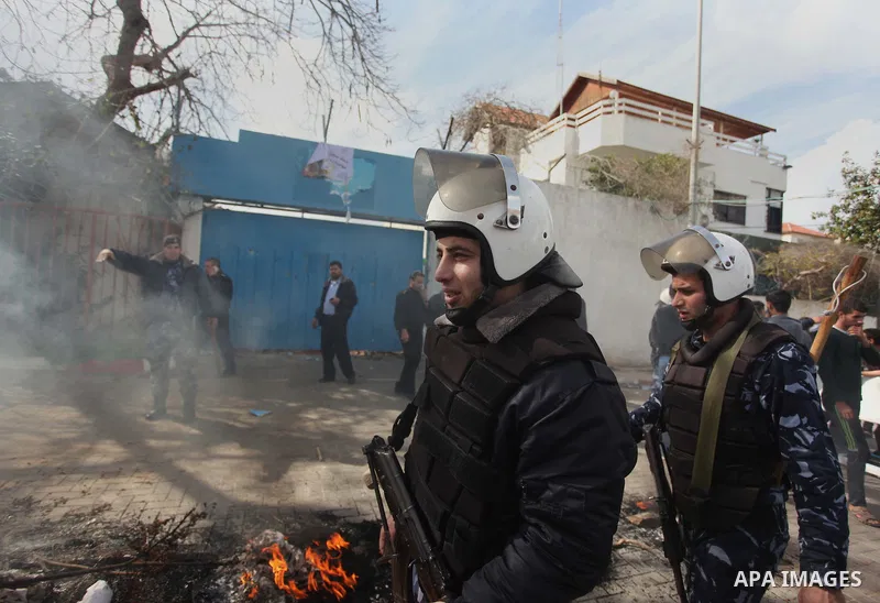 Palestinian policemen stand guard a protest against the decision by the main U.N. aid agency to suspend payments to tens of thousands of Palestinians for repairs to their homes damaged in last summer's war, outside the h...