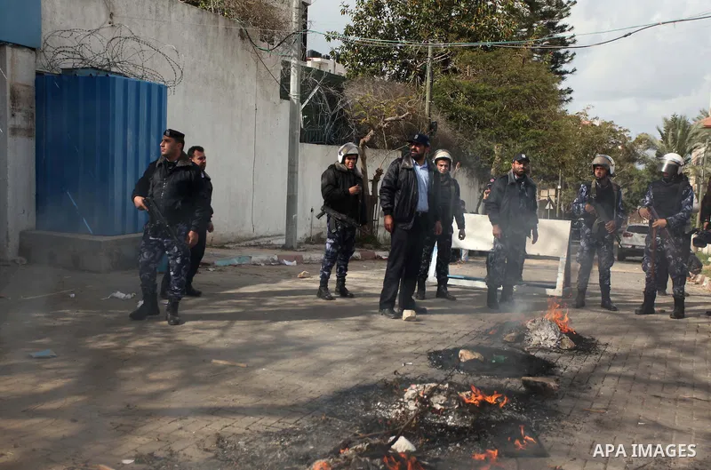 Palestinian policemen stand guard a protest against the decision by the main U.N. aid agency to suspend payments to tens of thousands of Palestinians for repairs to their homes damaged in last summer's war, outside the h...