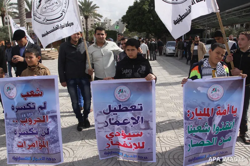 Palestinian supporters of al-Ahrar movement, take part a protest against the decision by the main U.N. aid agency to suspend payments to tens of thousands of Palestinians for repairs to their homes damaged in last summer...