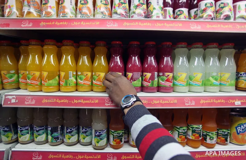A Palestinian man sorts bottles of Israeli-product juice, at a mall in Gaza city on January 28, 2015. Gaza's Ministry of Economy said Sunday that it would allow soft drinks, clothes, coffee, and other Israeli products in...