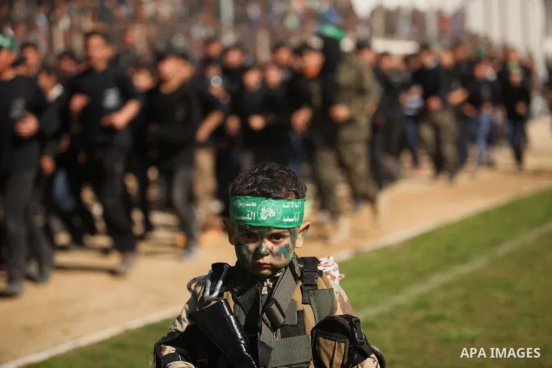 A Palestinian boy dressed as militants of Ezz eddin al-Qassam brigades poses during a graduation ceremony of a military-style camp organized by the Hamas movement in Gaza City on January 29, 2015. Hamas's armed wing orga...