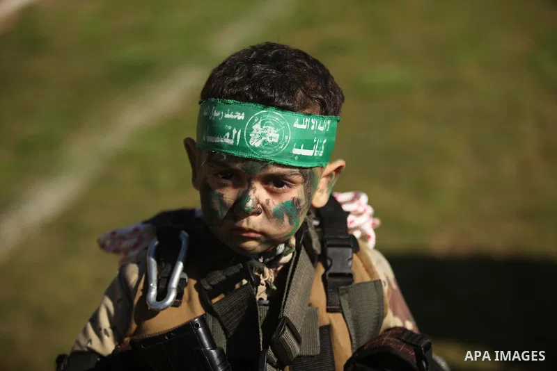 A Palestinian boy dressed as militants of Ezz eddin al-Qassam brigades poses during a graduation ceremony of a military-style camp organized by the Hamas movement in Gaza City on January 29, 2015. Hamas's armed wing orga...