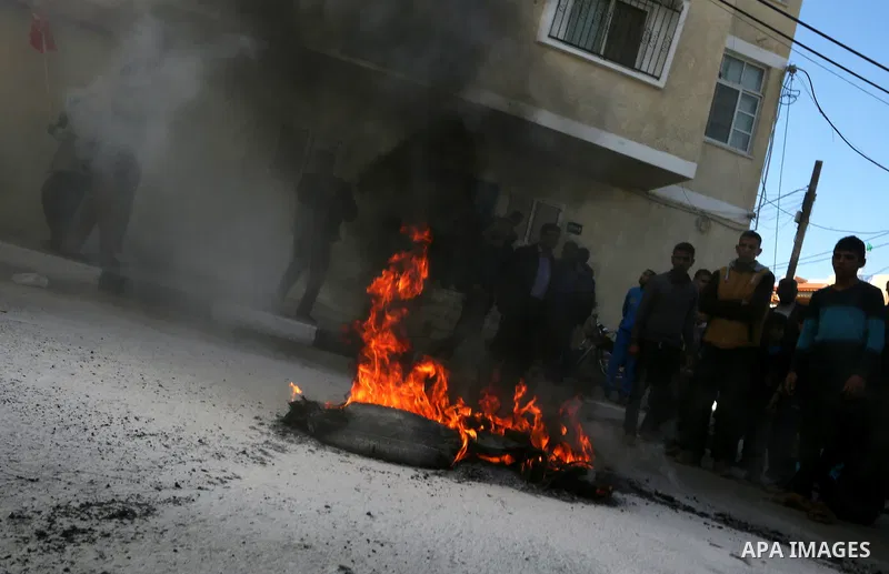 Palestinian protesters burn tires during a protest organised by the Democratic Front for the Liberation of Palestine against United Nations, after the UN announced a lack of funds to rebuild the Palestinian territory, ou...