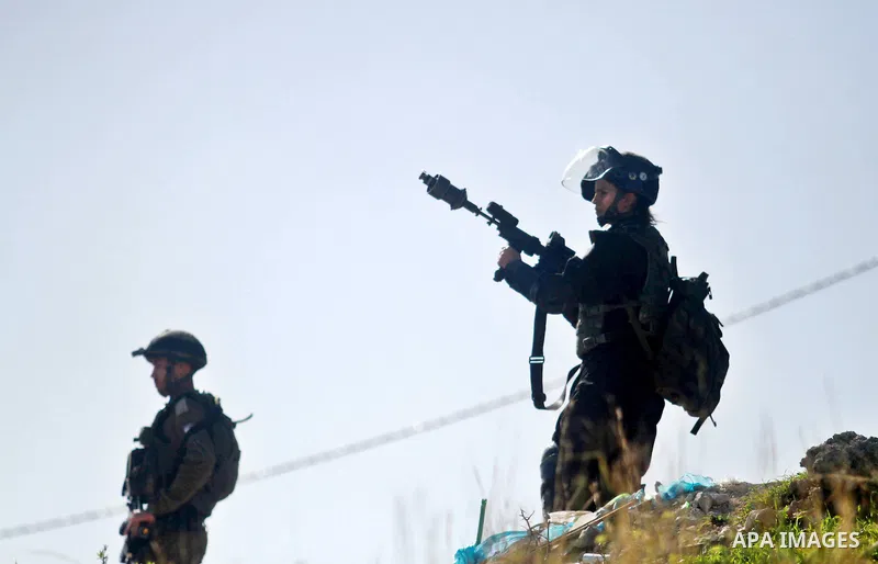 An Israeli soldier fires tear gas towards Palestinian protesters during clashes following a protest against the arrest of 14-year-old girl Malak al-Khatib, in the West Bank village of Bilin west of Ramallah, on January 3...