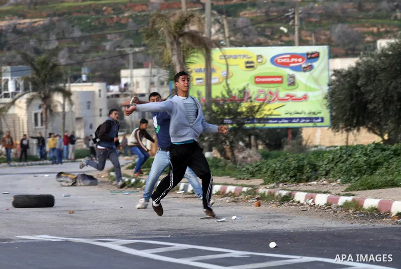 Palestinian protesters throw stones at an Israeli militaries during clashes in the village of Qusra, near Nablus in the occupied West Bank, on February 2, 2015. Israeli forces on Monday demolished two small farmhouses, a...