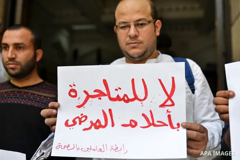 Egyptian employees of health sector hold banners during a protest against the claimed Hepatitis C cure invented by the Egyptian armed forces, in Cairo on February 3, 2015. Egyptian military had developed last year a cure...