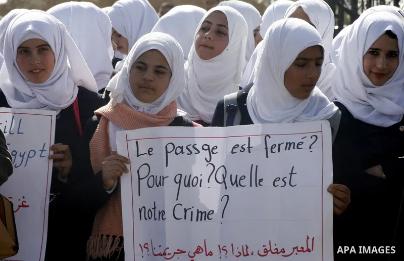 Palestinian students hold banners during a protest outside the Rafah crossing border, demanding the Egyptian authorities for the opening of the crossing, in Rafah in the southern Gaza Strip, February 4, 2015. Photo by Ab...