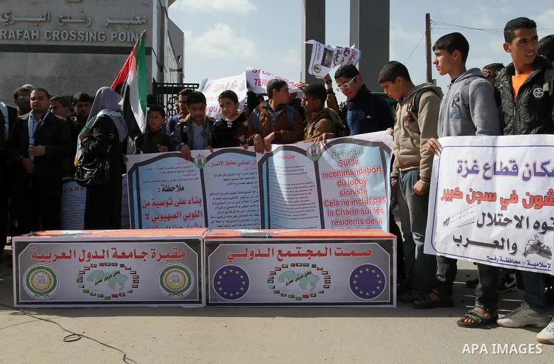 Palestinian students hold banners during a protest outside the Rafah crossing border, demanding the Egyptian authorities for the opening of the crossing, in Rafah in the southern Gaza Strip, February 4, 2015. Photo by Ab...