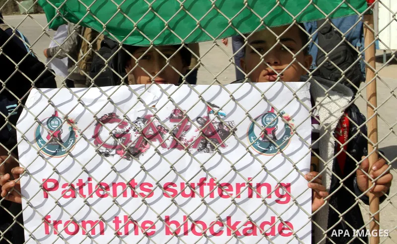 Palestinian students hold banners during a protest outside the Rafah crossing border, demanding the Egyptian authorities for the opening of the crossing, in Rafah in the southern Gaza Strip, February 4, 2015. Photo by Ab...