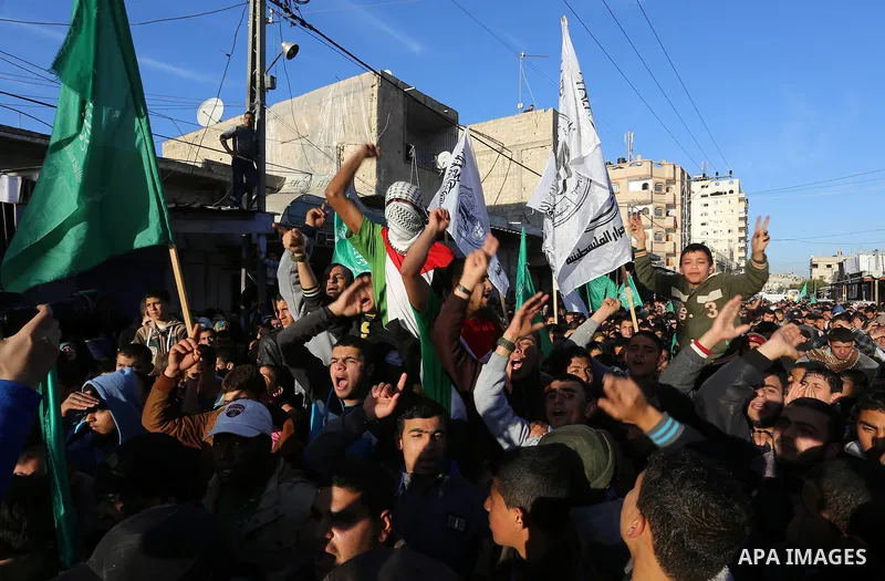 Palestinians shout slogans during a rally to condemn the decision of an Egyptian court to ban the armed wing of Palestinian Islamist movement, near the Rafah border between southern Gaza Strip and Egypt on February 5, 20...