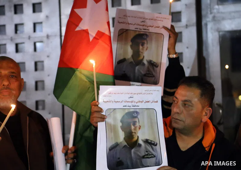 Palestinians hold candles and portraits of slain Jordanian pilot, Lt. Muath al-Kasasbeh, killed by the Islamic State group, during a candle light vigil outside the Nativity Church in the West Bank city of Bethlehem, Febr...