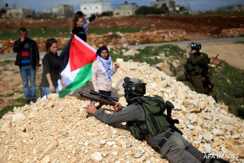 Palestinian girls wave a Palestinian flag in front of Israeli troops during clashes at a weekly protest against Jewish settlements, in the West Bank village of Nabi Saleh, near Ramallah February 6,2015. Photo by Shadi Ha...