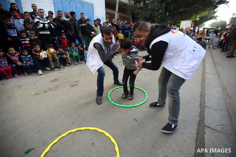 Volunteers of the Friday of Joy Initiative, play with Palestinian children in the street in al-Shati refugee camp, in Gaza city, February 6, 2015. Ten Palestinian volunteers organise street games, painting and drama, eve...