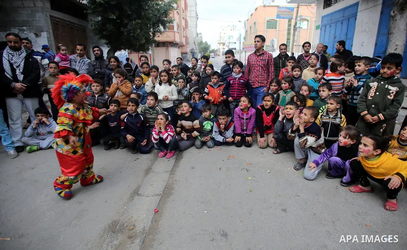 A clown performs in front of Palestinian children during a street game organised by volunteers of the Friday of Joy Initiative, in al-Shati refugee camp, in Gaza city, February 6, 2015. Ten Palestinian volunteers organis...
