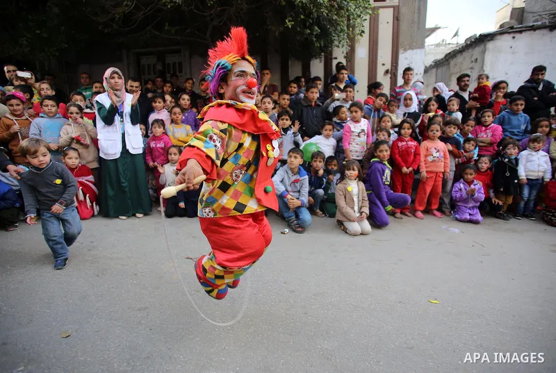 A clown performs in front of Palestinian children during a street game organised by volunteers of the Friday of Joy Initiative, in al-Shati refugee camp, in Gaza city, February 6, 2015. Ten Palestinian volunteers organis...