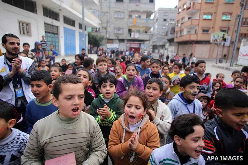 Palestinian children attend a street game organised by volunteers of the Friday of Joy Initiative, in al-Shati refugee camp, in Gaza city, February 6, 2015. Ten Palestinian volunteers organise street games, painting and...